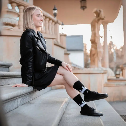 Zapatillas Casual Mujer Barefoot negras con calcetines de diseño de teclado de piano, chaqueta y vestido negros.