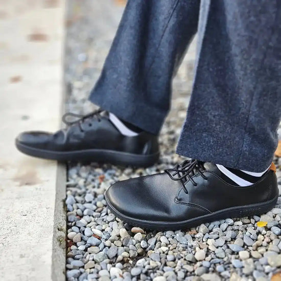 zapatos barefoot saguaro negros usados al caminar en entorno urbano