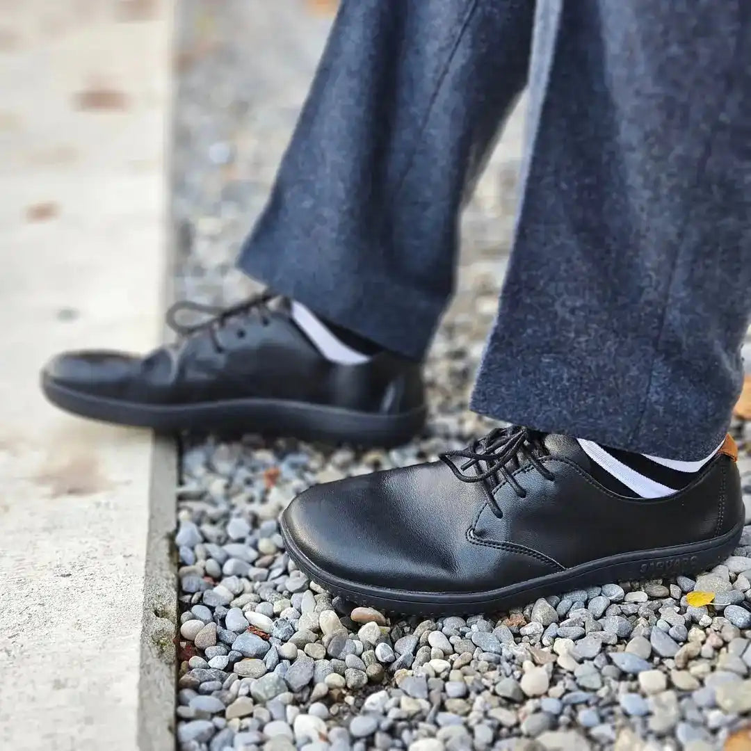zapatos barefoot saguaro negros usados al caminar en entorno urbano