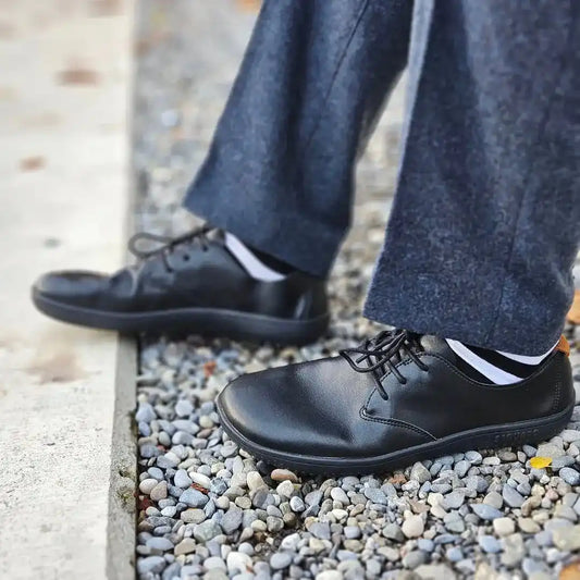 zapatos barefoot saguaro negros usados al caminar en entorno urbano