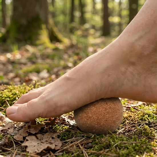Persona usando pelota de corcho en el arco para mejorar la postura barefoot.