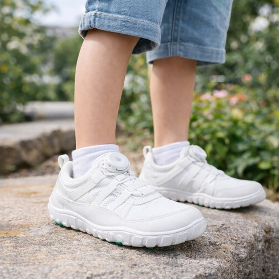 Niño usando calzado barefoot blanco. ideal para actividades extraescolares.