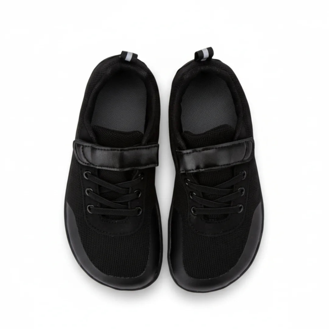 Bebe zapatillas negras con horma anatómica que permite el libre movimiento de dedos.