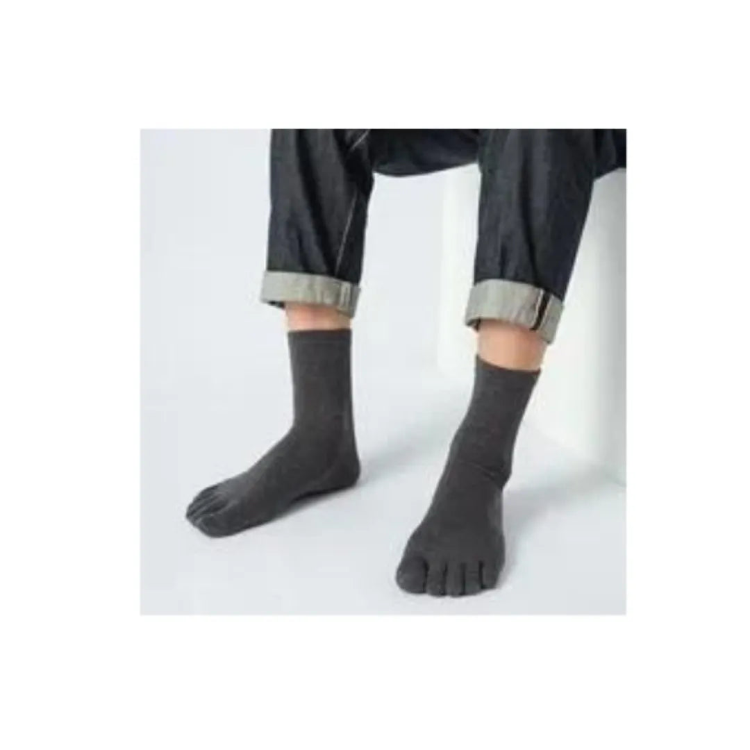 Calcetines grises de dedos largos usados con jeans, confort diario.