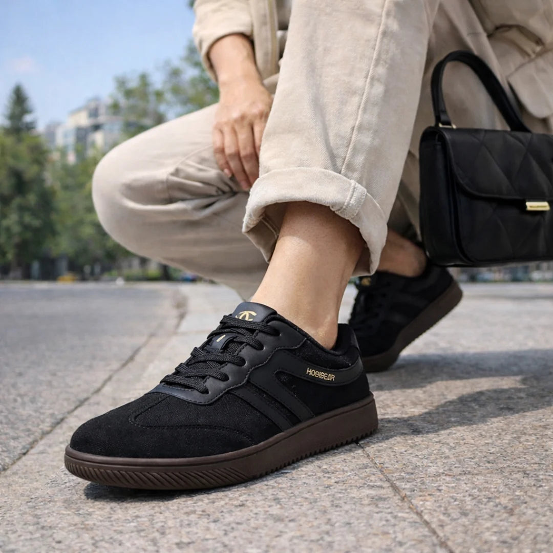 Mujer usando calzado minimalista negro en un entorno urbano, destacando versatilidad y confort.