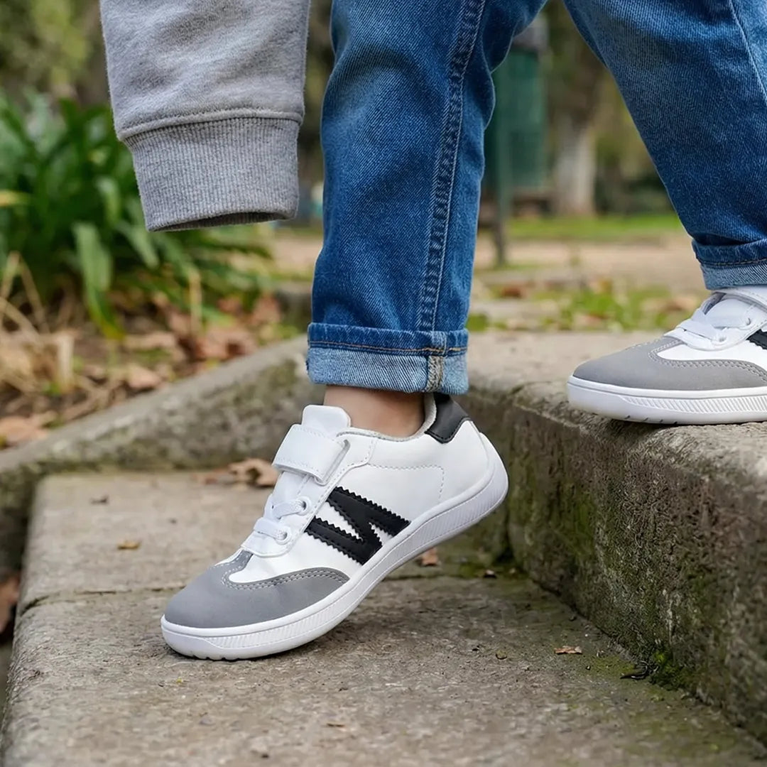 Niño bajando escaleras con calzado respetuoso ZZFaber, destacando el agarre antideslizante y la estabilidad del pie infantil.