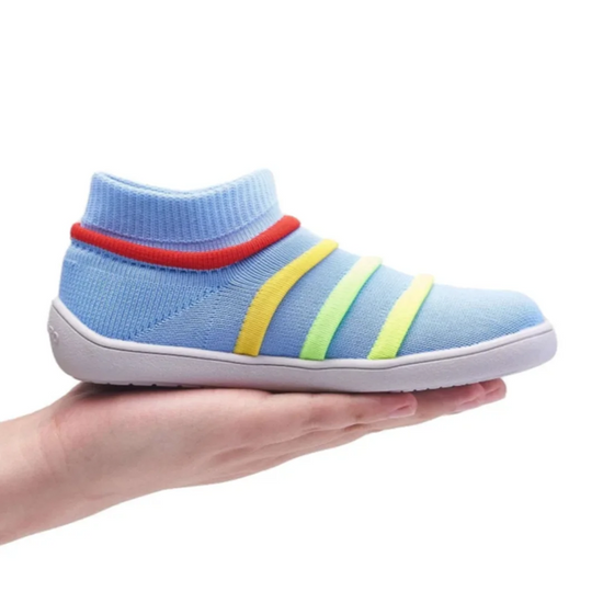 Primer plano de niño usando zapatillas minimalistas tipo calcetín.