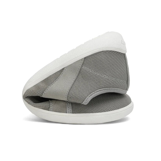 Zapatilla minimalista Saguaro gris doblada demostrando flexibilidad.