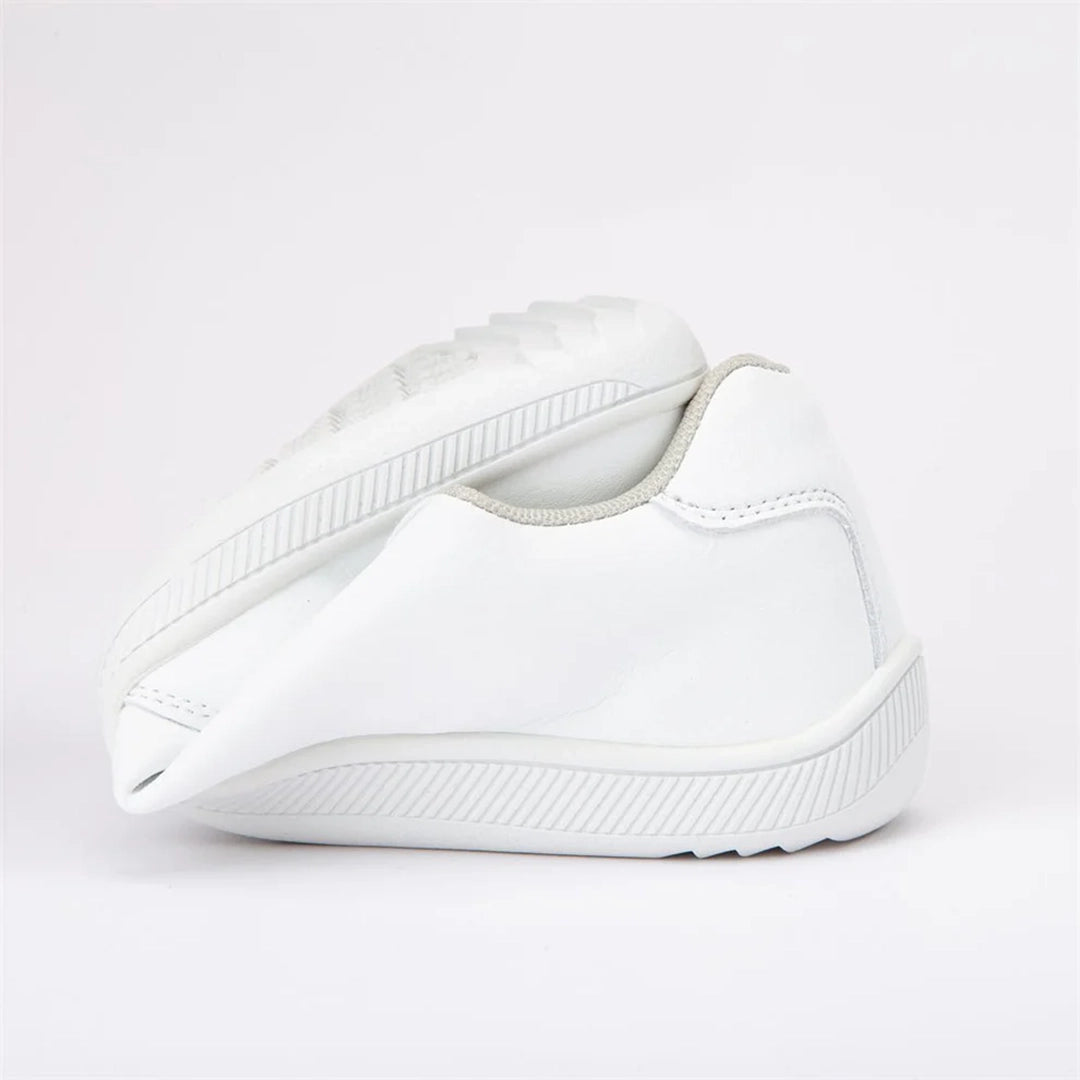 Zapatilla blanca torsionada mostrando suavidad del material.