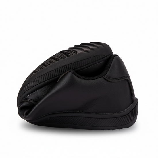 Zapatilla casual negra doblada por la mitad demostrando suela flexible.