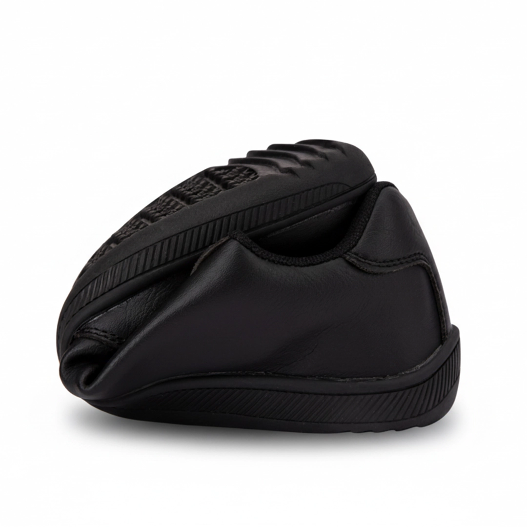 Zapatilla casual negra doblada por la mitad demostrando suela flexible.