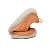 Zapatilla trail naranja doblada mostrando torsión y flexibilidad.
