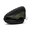 Zapatilla outdoor verde doblada mostrando suela flexible y resistente.