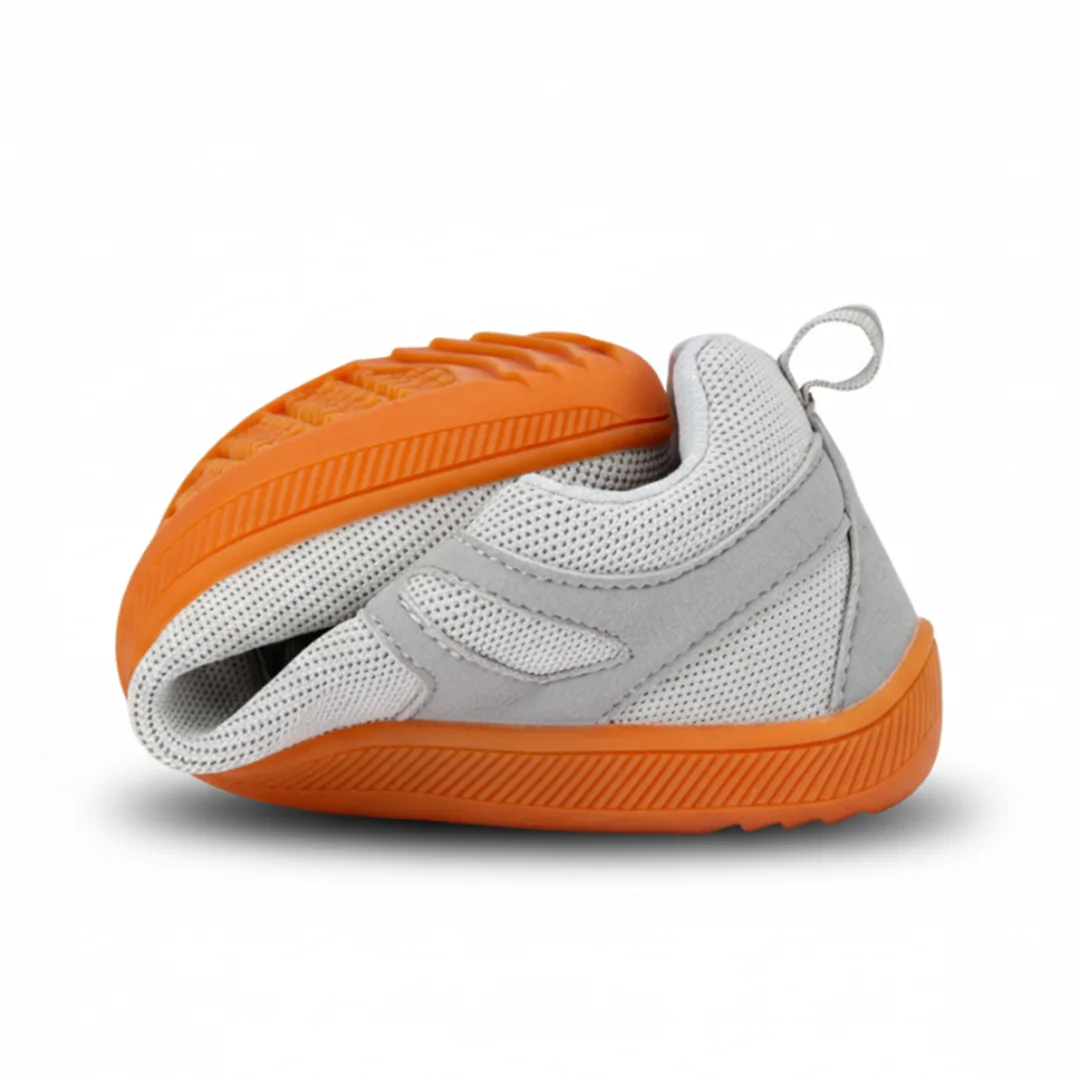 Zapatilla barefoot gris doblada demostrando su gran flexibilidad.