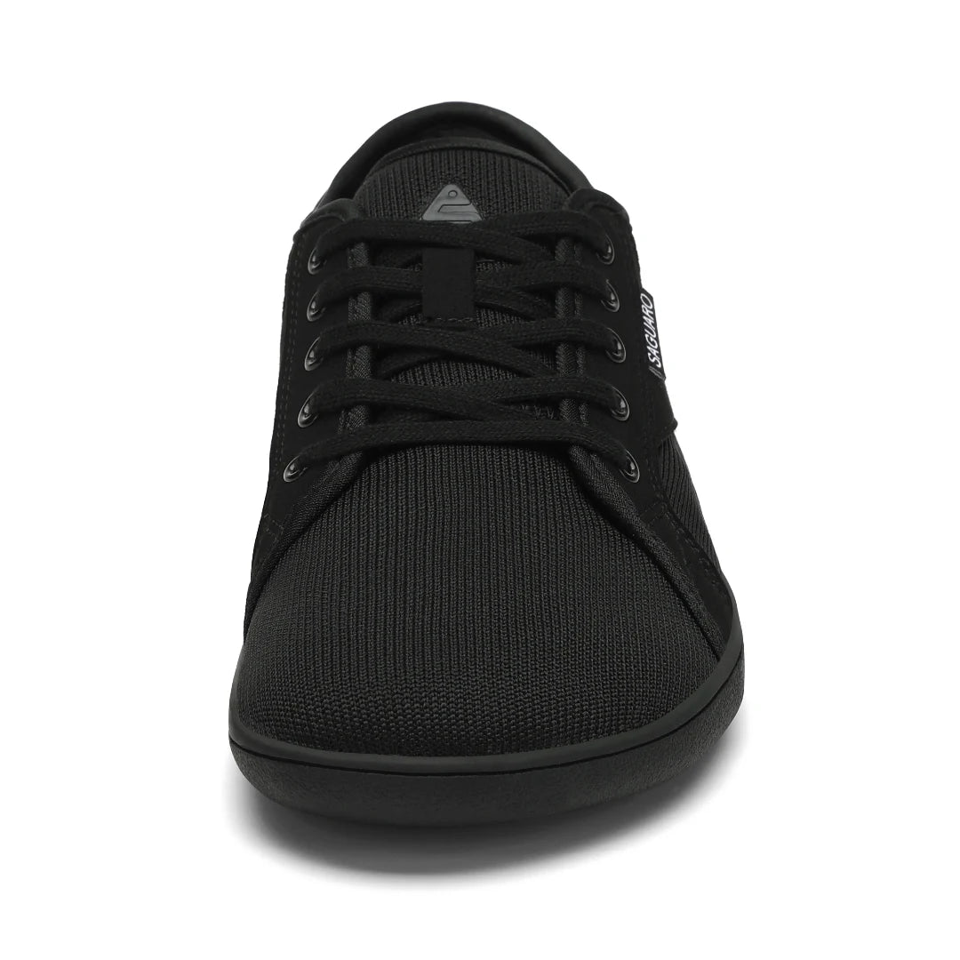 Zapatilla barefoot urbana frontal negra, suela delgada zero drop.