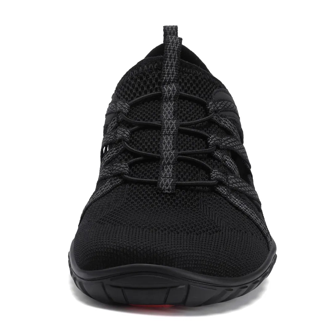 Vista frontal sandalia negra, puntera ancha y cordones elásticos.