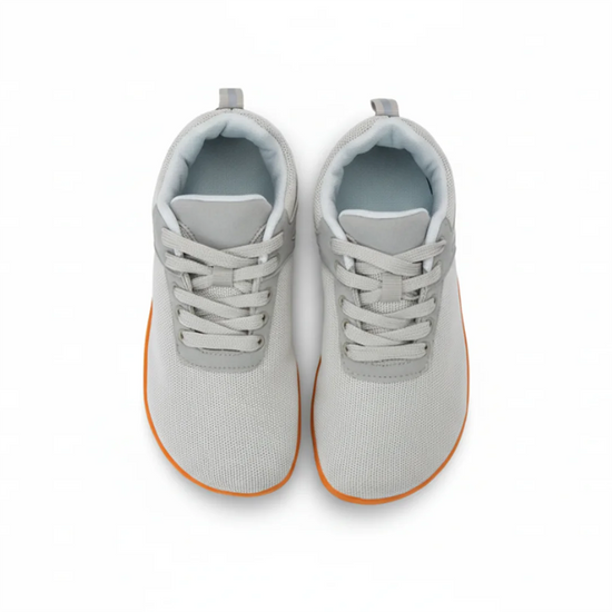 Vista superior de zapatillas minimalistas grises, diseño ergonómico.