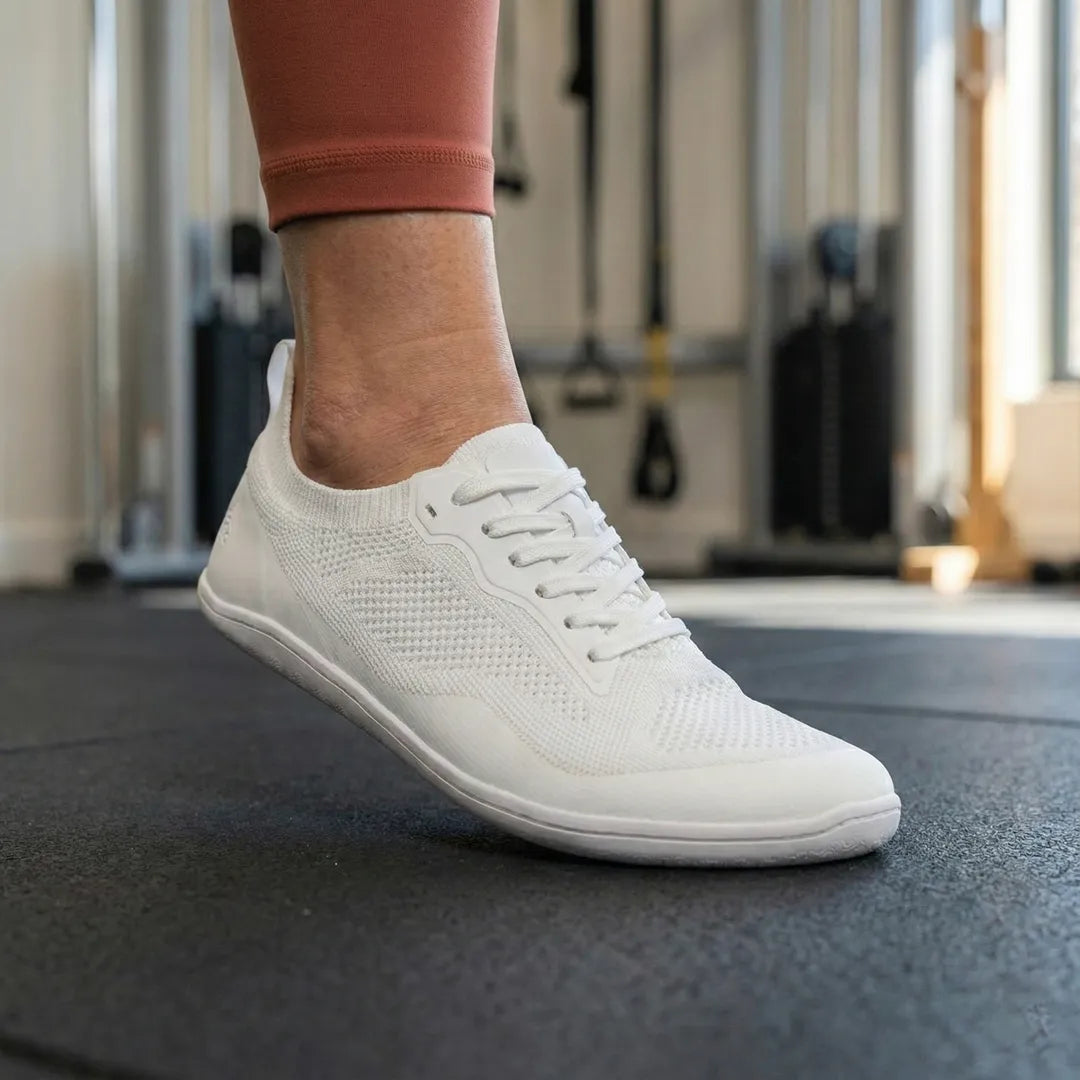 Mujer en el gimnasio utilizando Kenaz blancas de Sowilo Zapatilla Barefoot