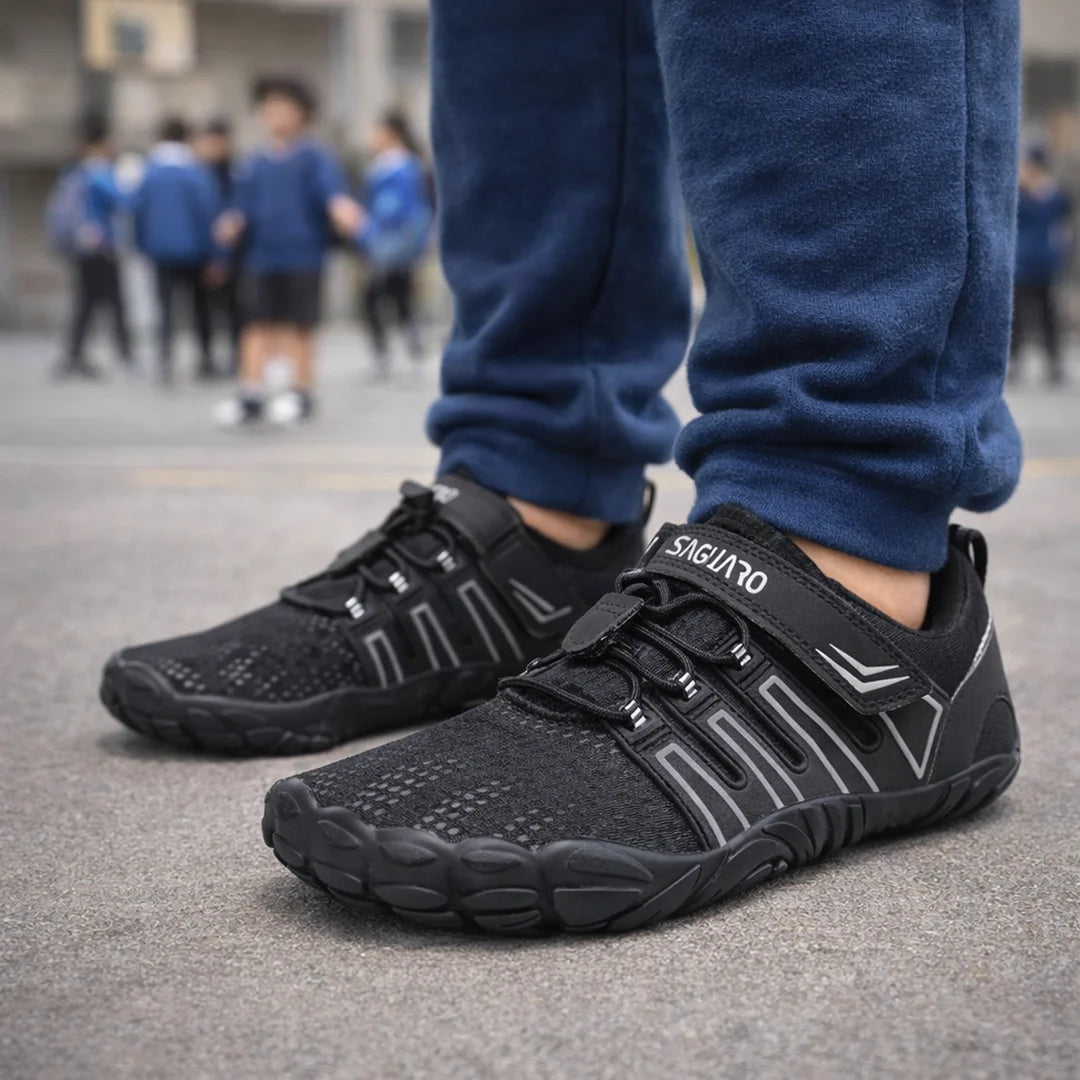 Niños en el patio del colegio usando zapato escolar barefoot negro Saguaro Vigor II.