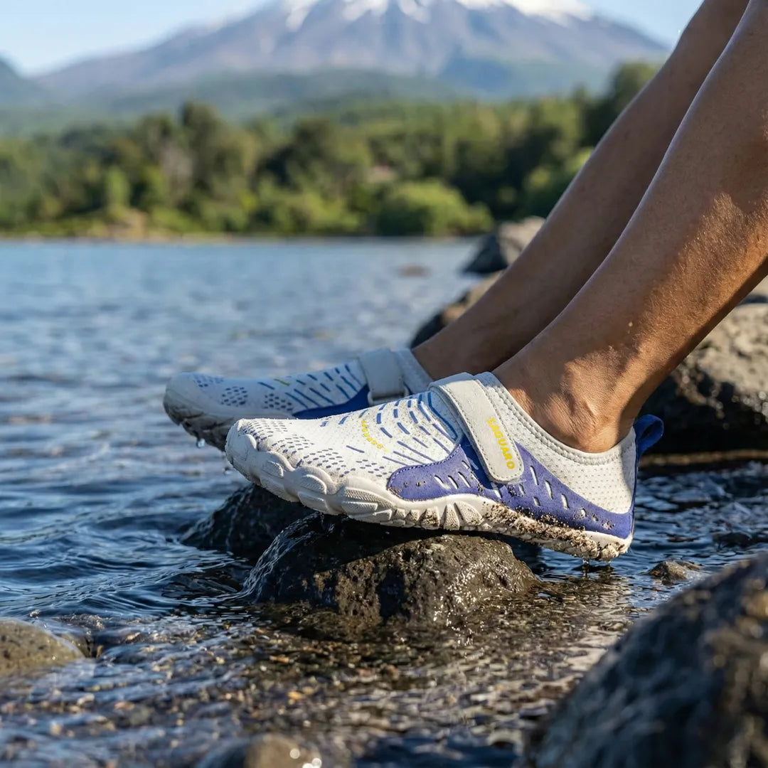 Mujer sentada en el lago Villarrica usando zapatillas de agua Saguaro azules.