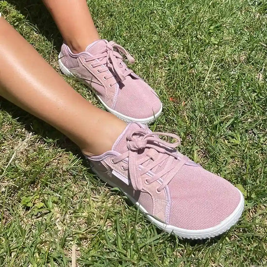 Mujer usando zapatillas Saguaro Luck I rosa en entorno urbano.