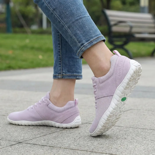 Mujer usando zapatillas Saguaro Wish I púrpura con jeans.