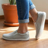 Mujer de pie usando zapatillas Saguaro Relax V gris con jeans.