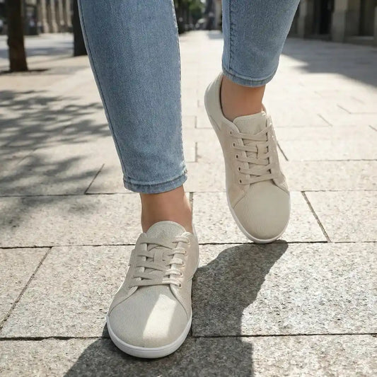 Persona usando zapatillas Saguaro Luck II crema en la ciudad.