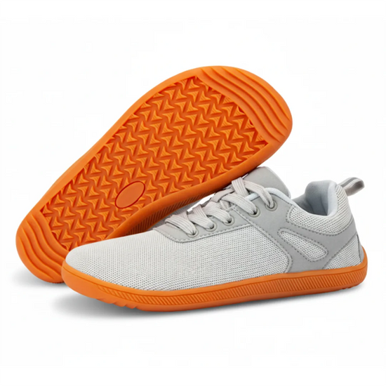 Vista frontal de zapatilla gris mostrando el amplio espacio para los dedos.