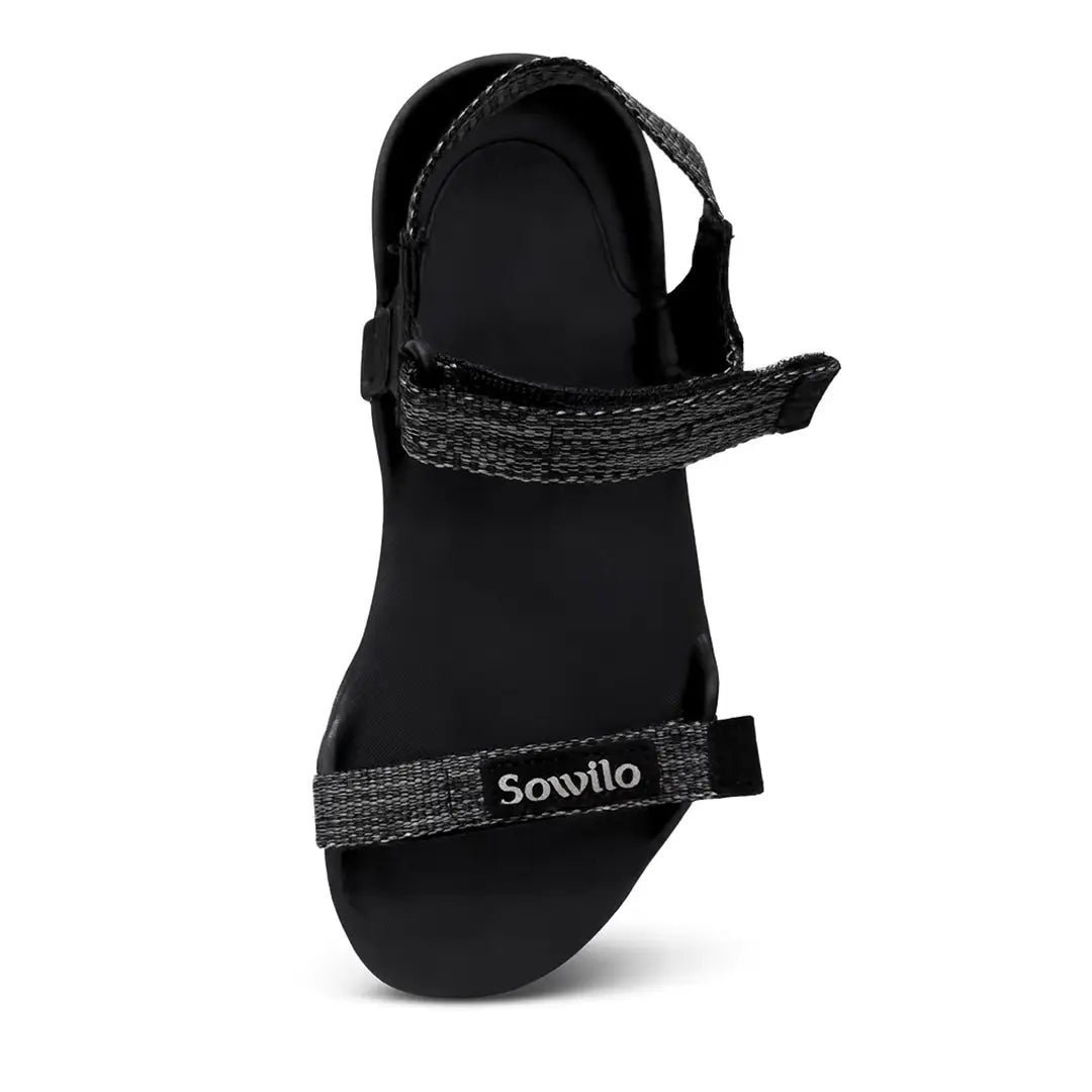 Sandalia Sowilo Raido negra vista frontal mostrando estructura plana barefoot.