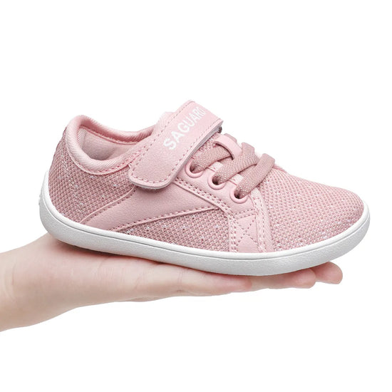 Zapatilla minimalista rosa infantil, suela flexible y fácil de calzar.