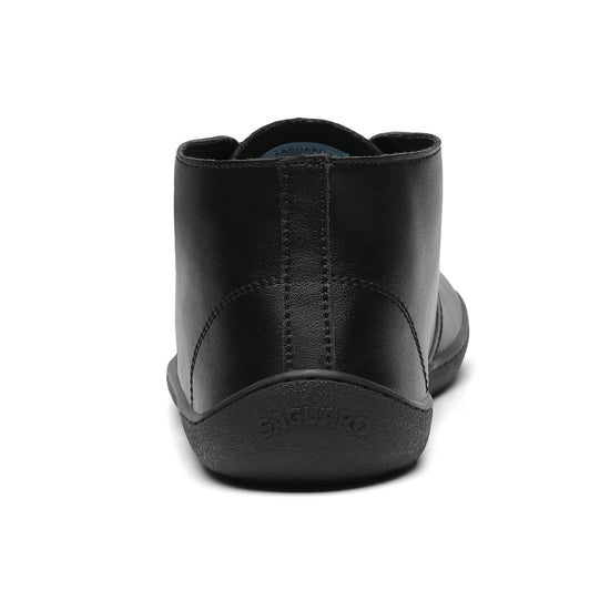 Vista posterior del zapato formal negro mostrando la suela plana sin elevación de talón.