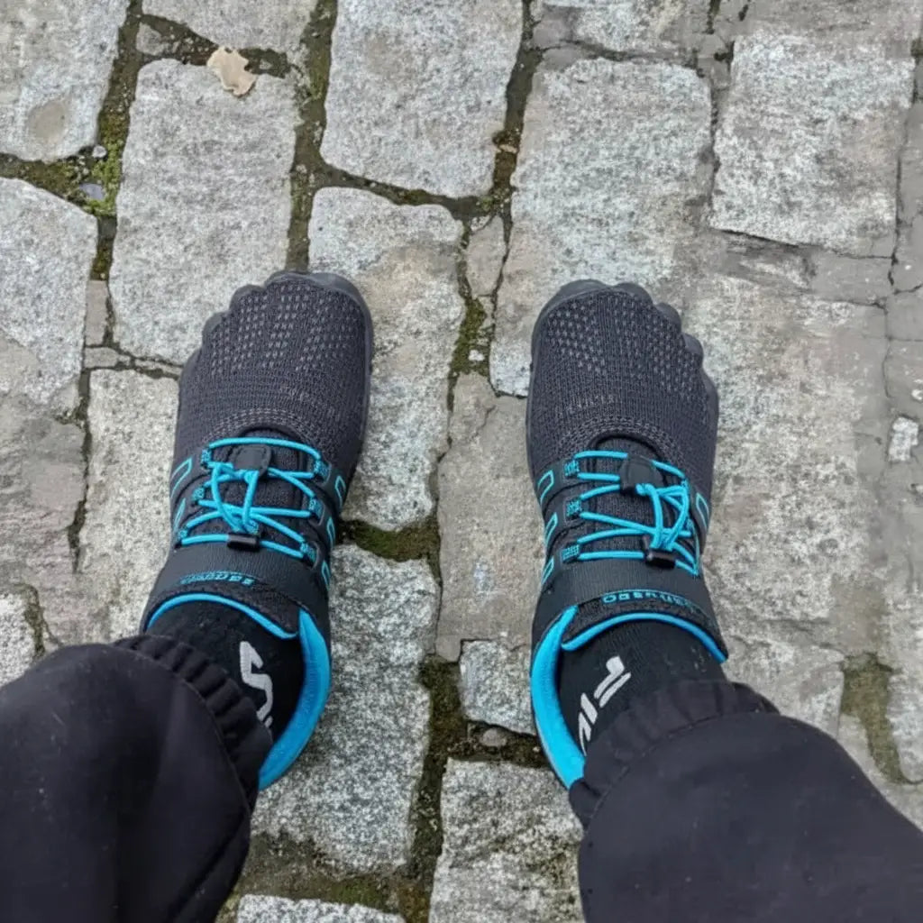 Persona usando zapatillas Saguaro Vigor II azules caminando en exterior.