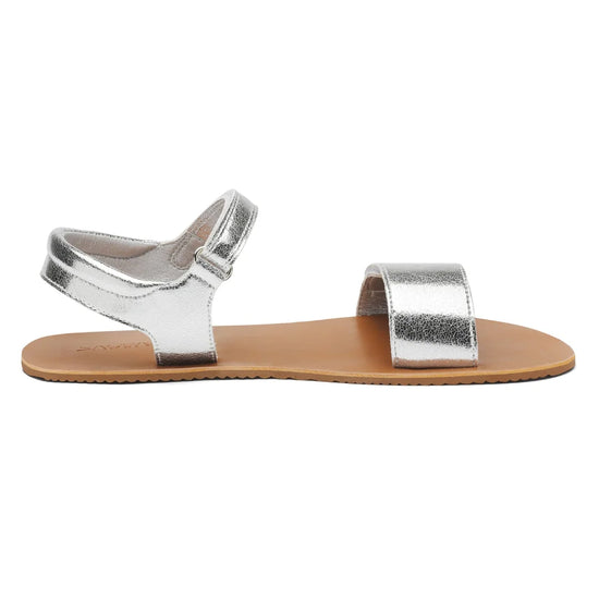 Vista lateral de sandalia barefoot Saguaro Glow I plateada con suela ultra delgada.