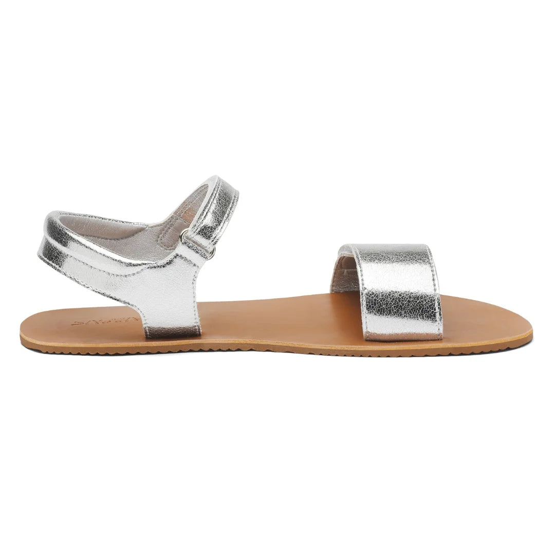 Vista lateral de sandalia barefoot Saguaro Glow I plateada con suela ultra delgada.