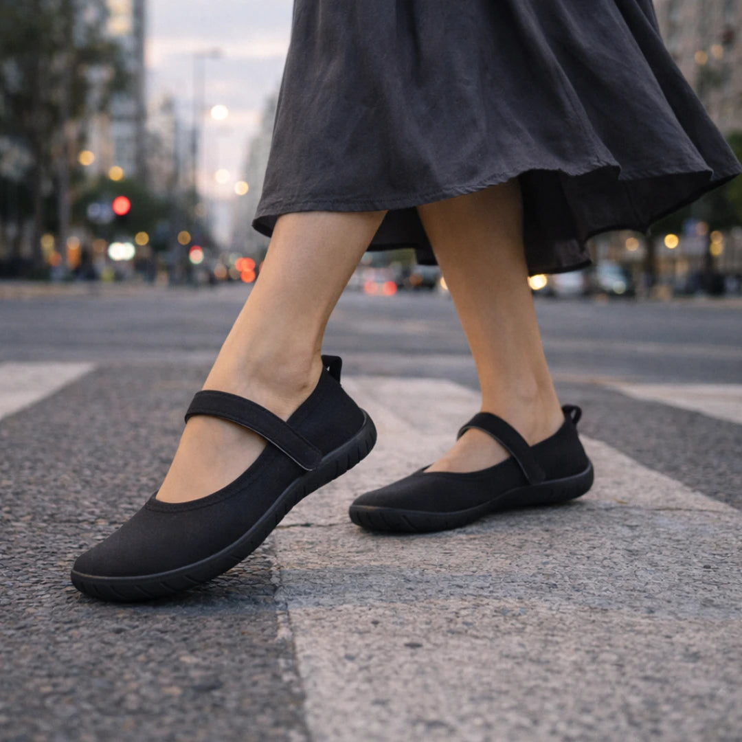 Mujer cruzando la calle con sandalias barefoot mujer tipo ballerinas negras de gran flexibilidad.
