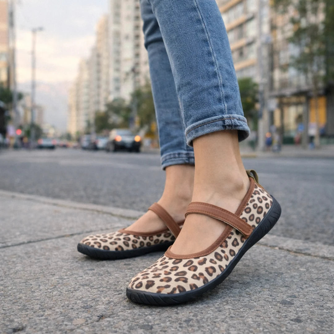 Mujer luciendo sandallas barefoot mujer tipo ballerinas con estampado de leopardo en un entorno urbano.