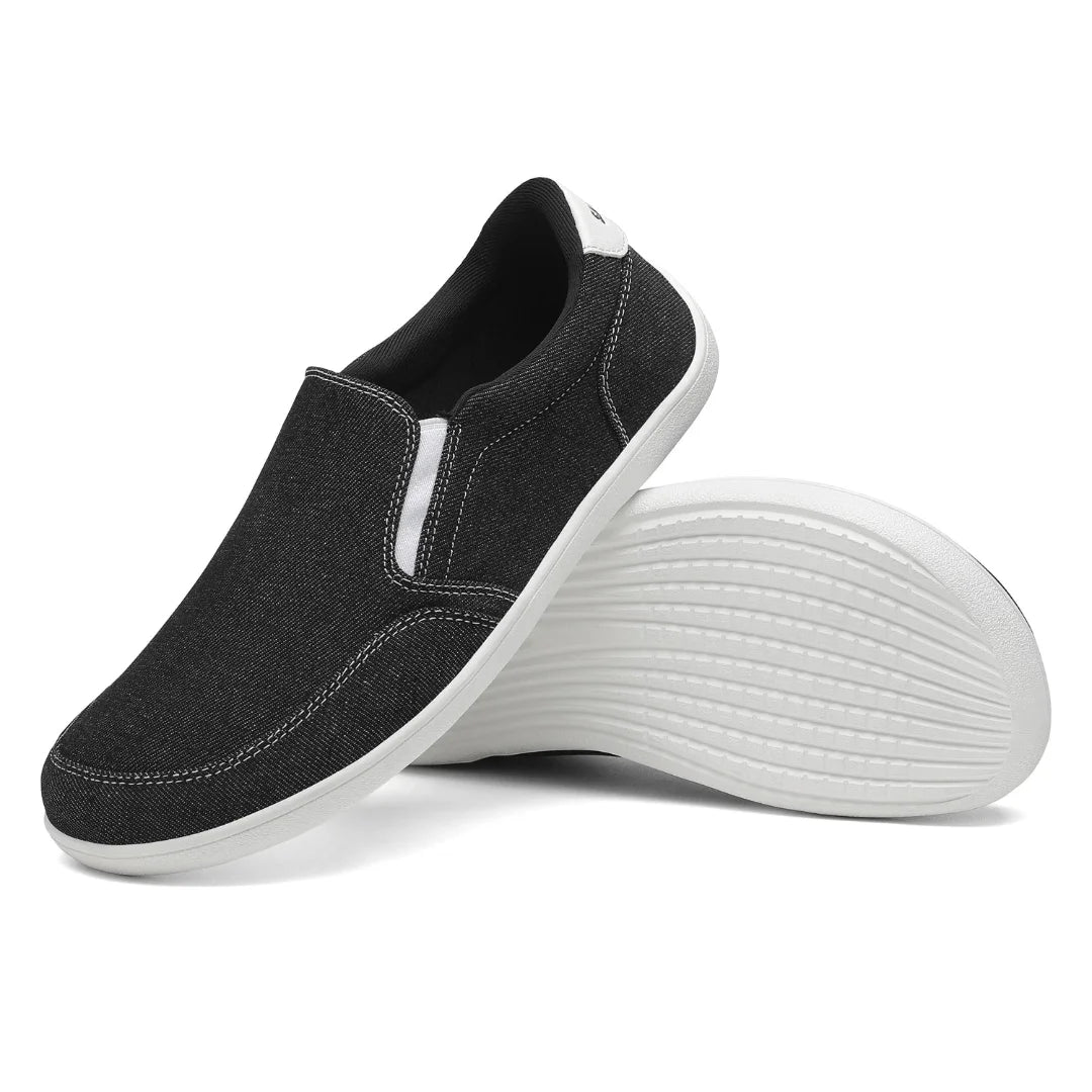 Suela blanca plana y flexible de zapatilla casual negra.