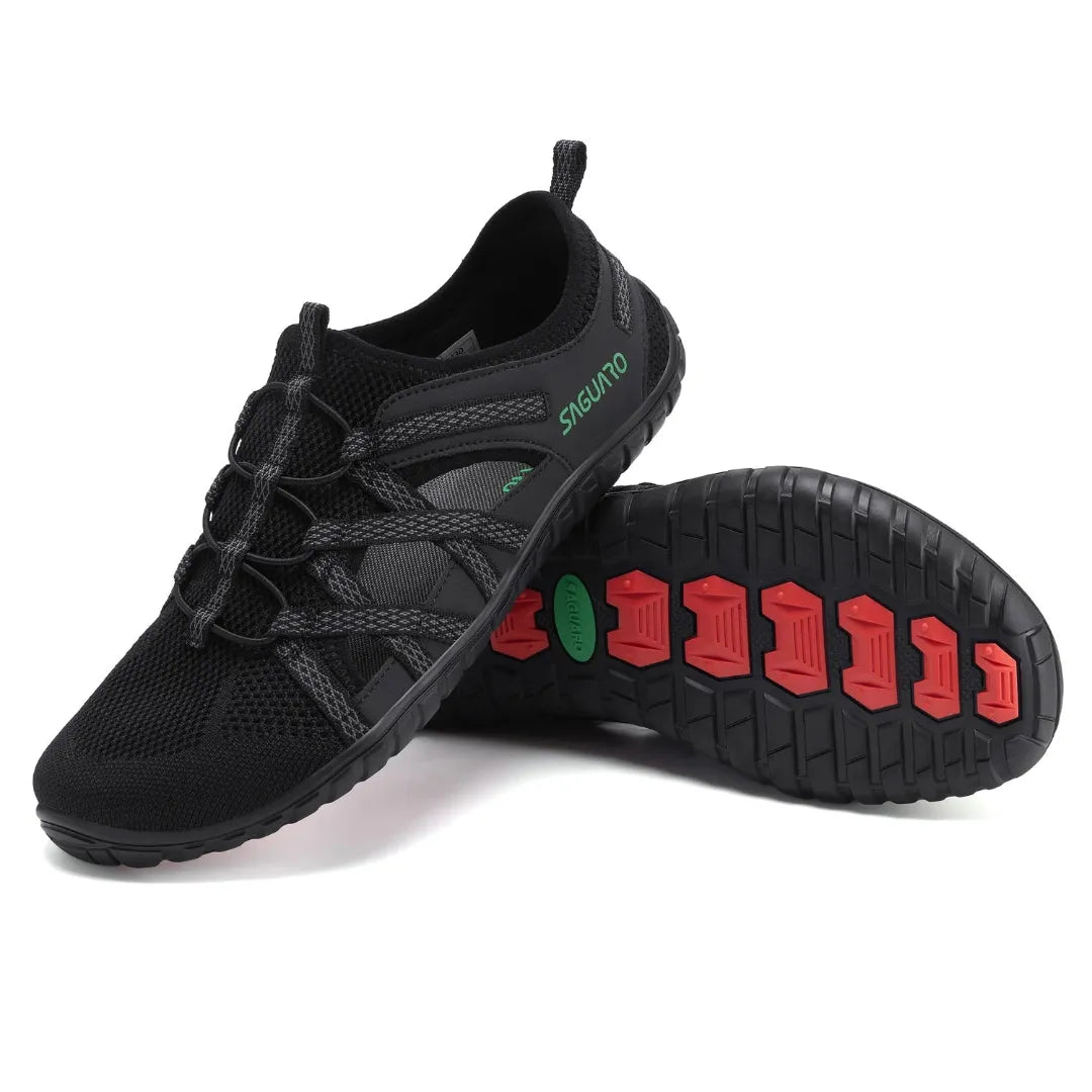 Suela outdoor negra con tacos rojos para tracción en roca y tierra.