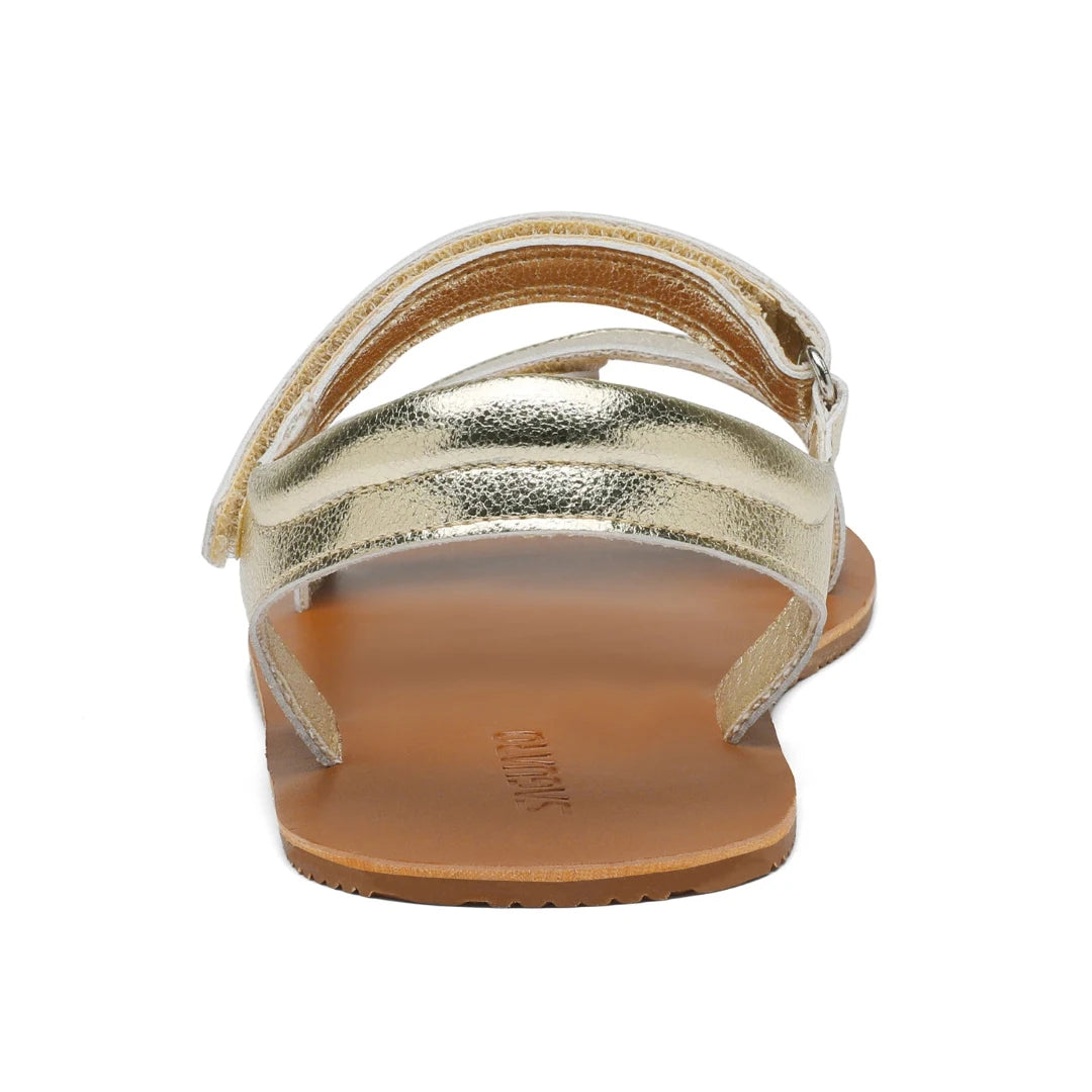 Detalle posterior del cierre de velcro ajustable en el talón de la sandalia dorada.