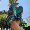 Persona usando Zapatilla Barefoot Saguaro Vitality IV Turquesa al aire libre. 