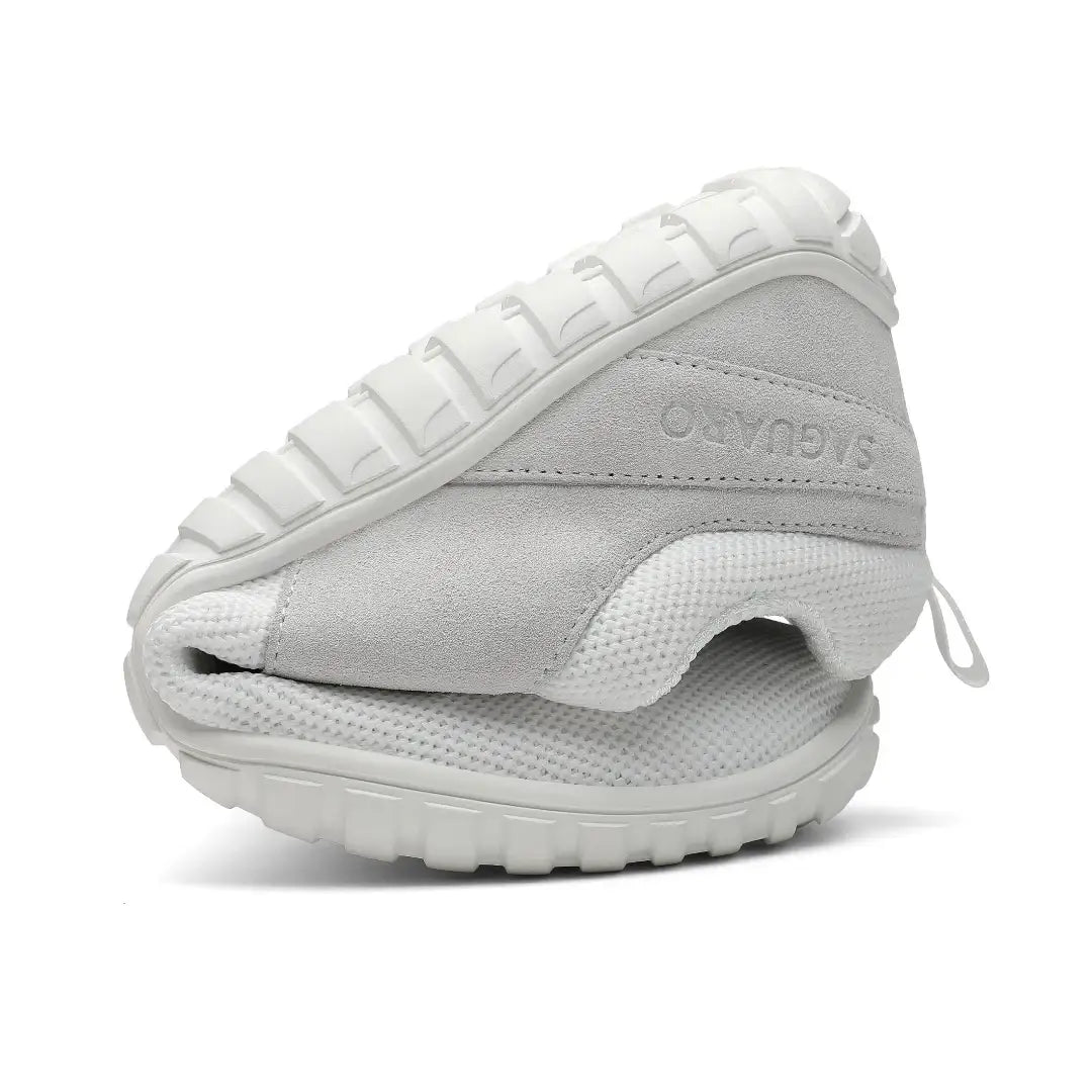 Zapatilla Saguaro Wish I blanca doblada demostrando flexibilidad natural barefoot.