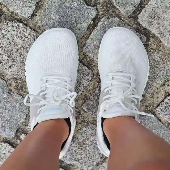 Persona usando Saguaro Wish I blancas caminando con pisada natural barefoot.