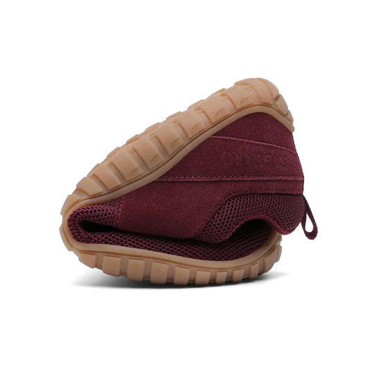 Zapatilla Saguaro Wish I vinotinto doblada demostrando su flexibilidad barefoot.