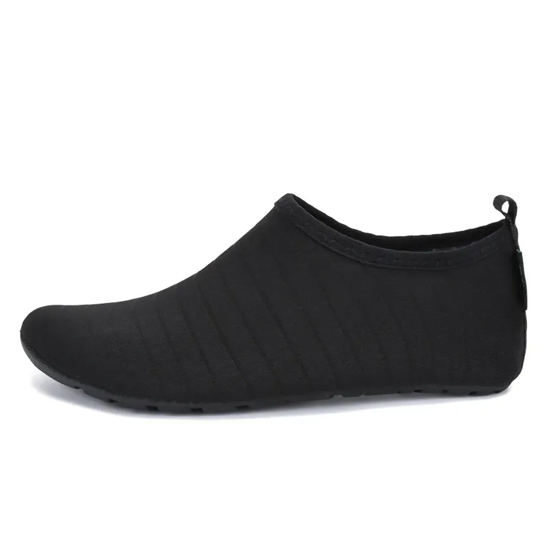 Zapatilla acuática minimalista negra, neopreno y secado rápido.