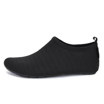Zapatilla acuática minimalista negra, neopreno y secado rápido.