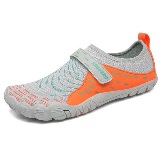 Zapatilla acuática barefoot gris con detalles naranjas, velcro y secado rápido.