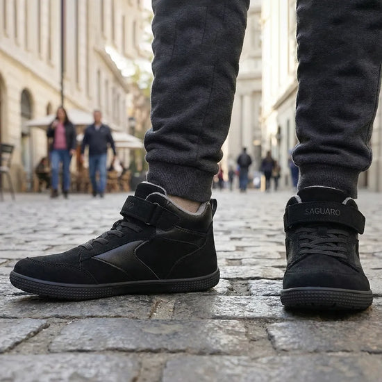 Niño usando zapatillas barefoot negras, caminando libremente por la ciudad. 