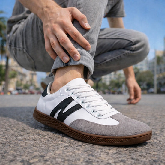 Primer plano de zapatillas anchas blancas para hombre con puntera de gamuza gris.