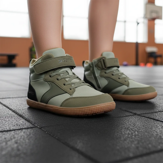 Niño en un entorno escolar usando zapatillas anchas infantiles Saguaro color verde olivo.